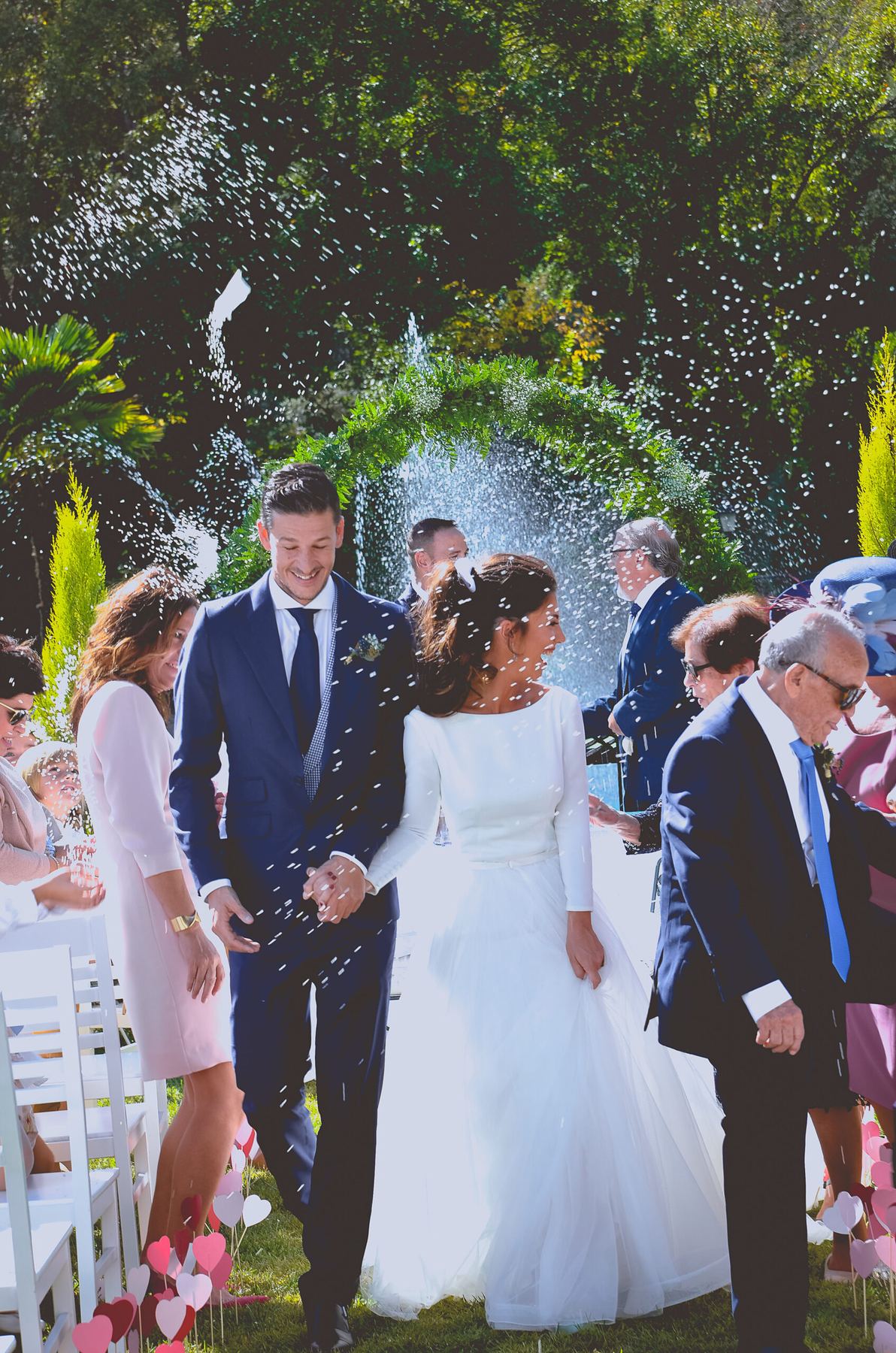 Novios saliendo de la ceremonia al aire libre