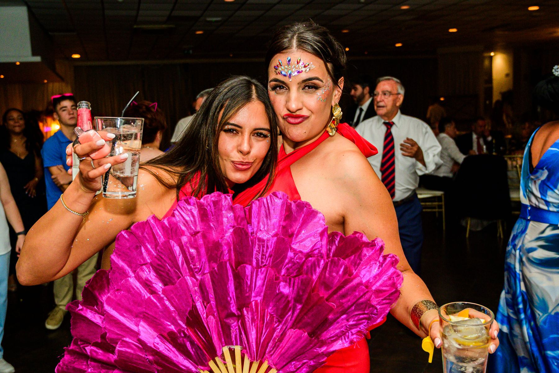 Invitadas de fiesta con abanico durante el convite